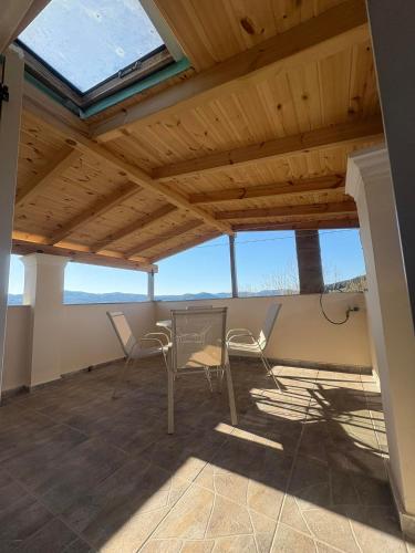a room with a table and chairs on a roof at Alex house in Kouramaditika