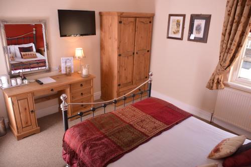 a bedroom with a bed and a desk and a mirror at The Rose & Crown York in York