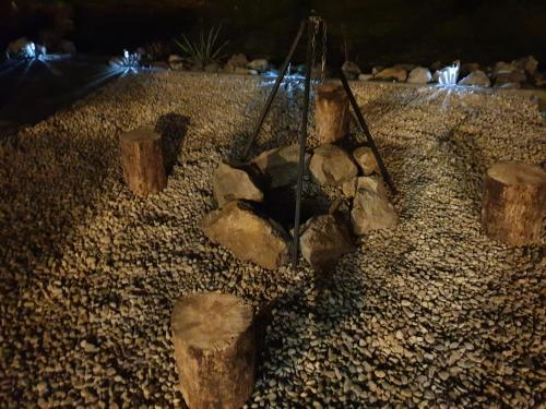 a group of logs and rocks on a beach at night at Belezúg-Lak vendégház in Nekézseny