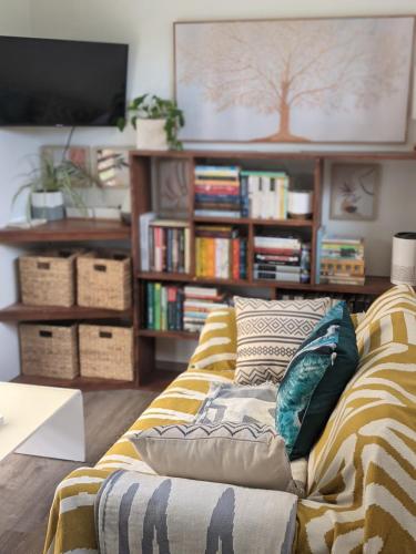 a living room with a couch and a book shelf at Brand New! Black Sand Beach-Casa NoSe' in Vieques