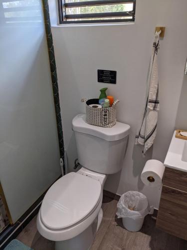 a bathroom with a white toilet and a sink at Brand New! Black Sand Beach-Casa NoSe' in Vieques