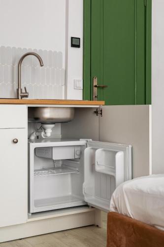 an open refrigerator in a kitchen with a sink at AMS Cluj Central Stay Boutique in Cluj-Napoca