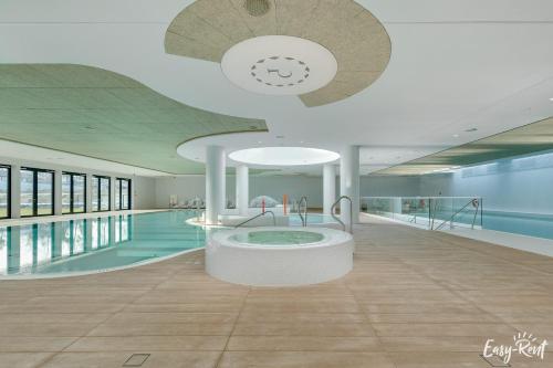 a swimming pool with a large ceiling in a building at Prestige Pinea 610 - basen, sauna, jacuzzi w cenie pobytu - Easy - Rent Apartments in Pobierowo