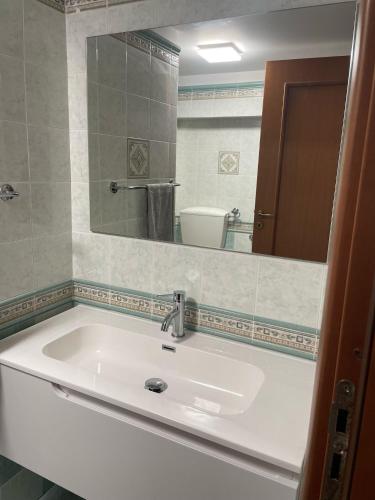 a bathroom with a white sink and a mirror at Finestra sul golfo in Balestrate