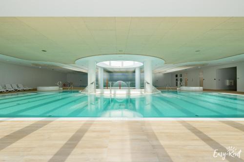 a large swimming pool in a building at Prestige Pinea 610 - basen, sauna, jacuzzi w cenie pobytu - Easy - Rent Apartments in Pobierowo