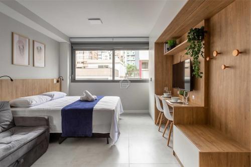 a room with a bed and a couch and a table at Apartamento completo localizado em um dos melhores bairros de Porto Alegre. in Auxiliadora