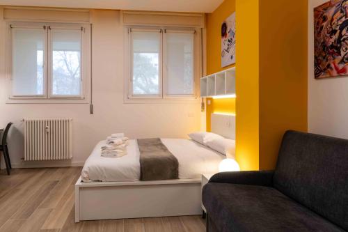 a small bedroom with a bed and a couch at Locami Bi-Apartments Padova in Padova