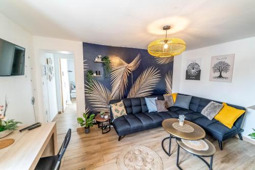 un salon avec un canapé bleu et une table dans l'établissement Maison familiale Terrasse Jacuzzi Parking sur place près d'Honfleur, à Équemauville