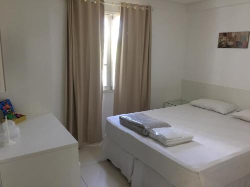 a white bedroom with a bed and a window at Pousada Lorde Inglês in Recife