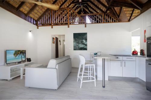 a kitchen and living room with a couch and a table at Moorea Sunset Beach in Haapiti