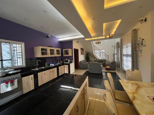 a large kitchen with purple walls and a living room at Afan Yaoundé Lodge in Yaoundé
