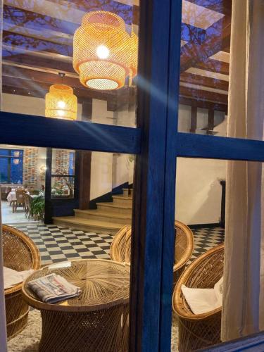 - une vue sur une chambre dotée de tables et de chaises à travers une fenêtre dans l'établissement Les Platanes, à Raucoules