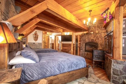 Un dormitorio con una cama y una chimenea de piedra. en The Castles on Schweitzer, en Sandpoint