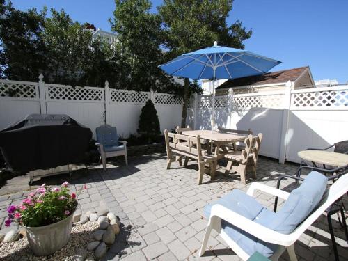 a patio with a table and a blue umbrella at Peters 2680 in Beach Haven Crest