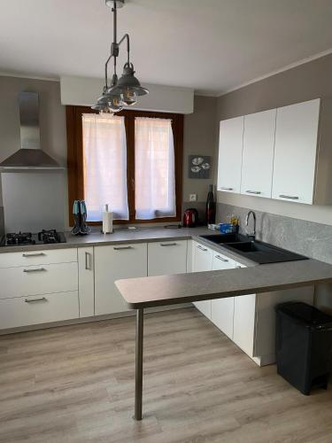 une cuisine avec des armoires blanches et une table à l'intérieur dans l'établissement Maison avec jardin, à Dunkerque