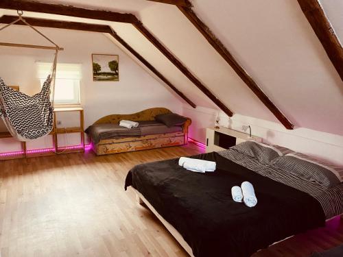 a attic bedroom with two beds and a swing at Kuća za odmor Bećarsko Utočište in Vinkovci