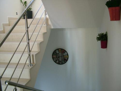 a clock on a wall in a stair case at Sugar and Almond in Agios Stefanos