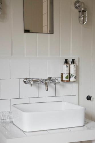 a white bathroom with a sink and a mirror at Bel and The Dragon-Kingsclere in Kingsclere