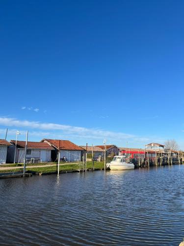 a boat is docked at a dock on the water at Charmant duplex Audenge in Audenge