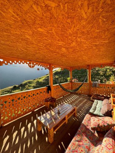 a room with two beds and a hammock on a porch at Guesthouse hegho სასტუმრო ჰეღო in Omalo