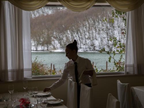 a woman is standing at a table in a restaurant at Parco del Lago Resort & SPA in Villagrande