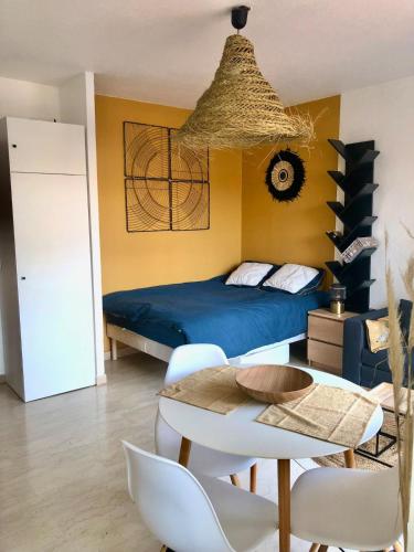 une chambre avec un lit, une table et des chaises dans l'établissement Grand studio terrasse climatisé central et calme, à Saint-Raphaël
