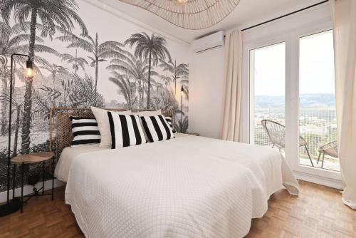 - une chambre avec un lit et une fresque murale sur les palmiers dans l'établissement KOENIG - T3 de standing avec balcon Parking et Vue, à Marseille