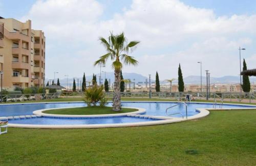a palm tree in the middle of a swimming pool at Apartamento Leticia in La Tercia