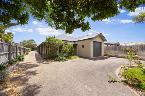 a home with a fence and a driveway at Maori in Rye walk to the beach and shops in minutes in Rye
