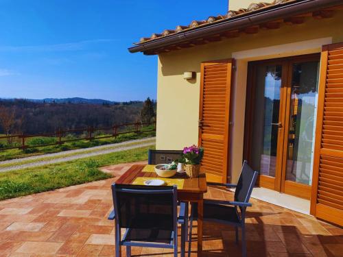 a wooden table and chairs on a patio at Casale SoleLuna - Bagno condiviso in Sorrezzana