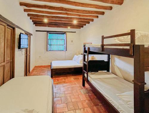 a room with two bunk beds and a room with a window at Achiotte by Masaya Collection in Barichara