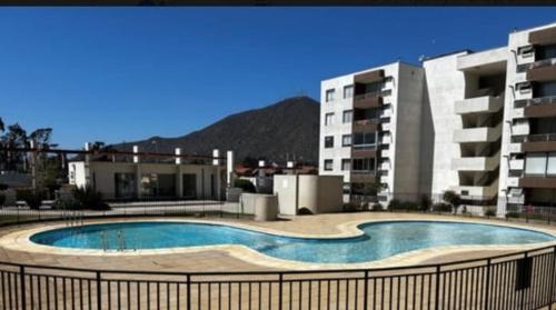 a large swimming pool in front of some buildings at Cómodo Apartment La Serena in La Serena