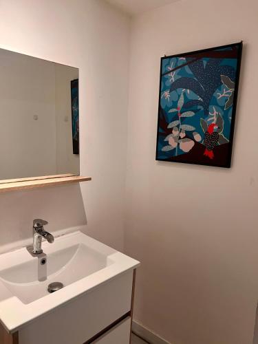 La salle de bains est pourvue d'un lavabo et d'une photo murale. dans l'établissement 5- les érables mauves, à Poitiers