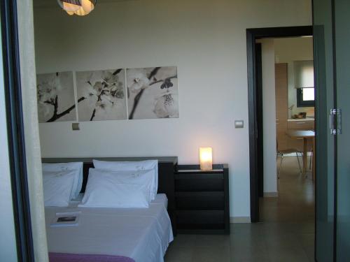 a bedroom with a bed with white sheets and pillows at Sugar and Almond in Agios Stefanos