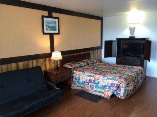 a hotel room with a bed and a couch at Carleton Motel and Coffee Shop in Borden-Carleton