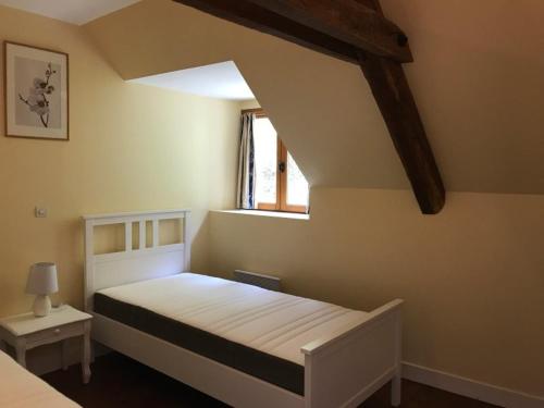 una camera da letto con un letto bianco e una finestra di Willow Cottage a Saint-Hilaire-sur-Bénaize
