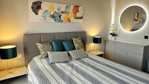 a bedroom with a bed and two lamps and a mirror at Sea view el veril in Adeje
