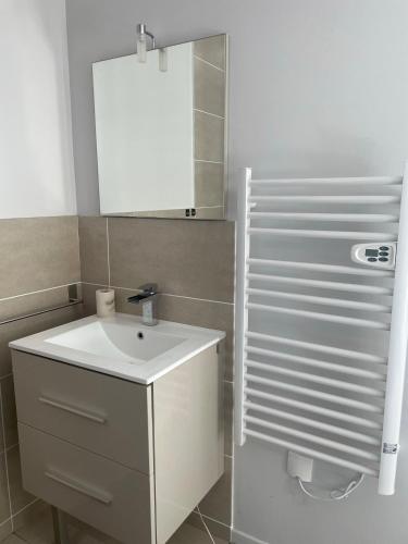 une salle de bain avec un lavabo blanc et un miroir dans l'établissement Villa entière piscine jacuzzi venelles, à Venelles