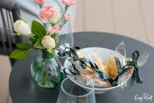 a table with a vase of flowers and a bowl of food at Prestige Pinea z basenem - Easy - Rent Apartments in Pobierowo