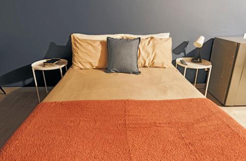 a bed with two tables and two pillows on it at Apartahotel Poblado-Aguacatala in Envigado