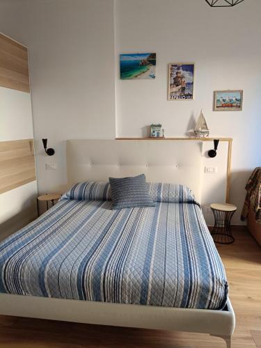 a bedroom with a bed with a blue striped comforter at Apartment/Studio il Girasole in Rapallo