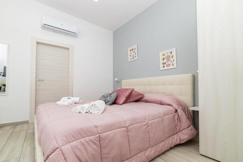 a bedroom with a pink bed in a white room at Vigna delle Rose in Trecase