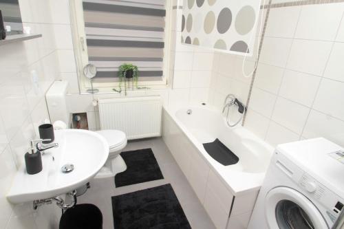 a white bathroom with a sink and a washing machine at Ruheoase mitten in der Stadt in Pirmasens