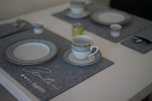 a table with plates and a coffee cup on it at Ruheoase mitten in der Stadt in Pirmasens