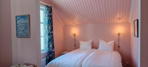 a bedroom with a white bed with two pillows at Wiisalan Kartano in Savonlinna