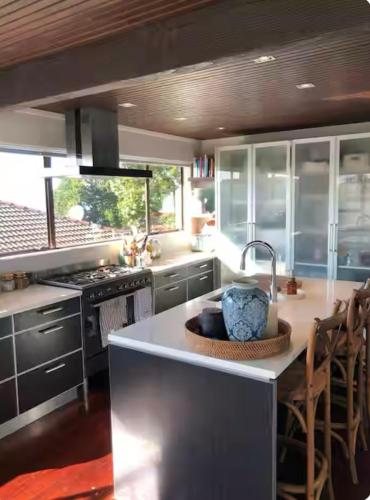 a large kitchen with a sink and a stove at Villa Del Mar Seaside Escape in Orewa