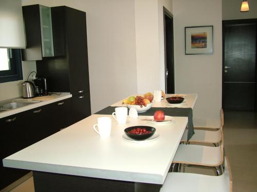 a kitchen with a table with bowls of fruit on it at Sugar and Almond in Agios Stefanos