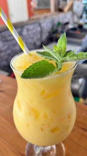 a drink with a mint leaf in a glass at Cabañas rio chovellen in Curanipe
