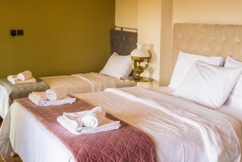 a bedroom with two beds with towels on them at Villa de Vino in Ioannina
