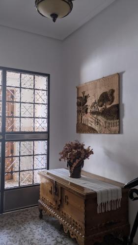 a room with a table with a vase on it at Casa de la Sirena in Baena